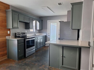 Kitchen featuring kitchen peninsula, stainless steel appliances, sink, and wooden walls