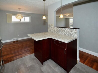Kitchen peninsula provides seating for dining in t