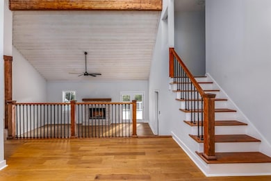 Staircase featuring baseboards, wood finished floo