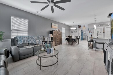 Living room with ceiling fan and sink