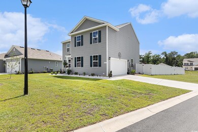View of front of home with a garage, driveway, board and batten siding, and a gate