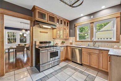 Kitchen featuring pendant lighting, a notable chandelier, light tile patterned floors, appliances with stainless steel finishes, and sink