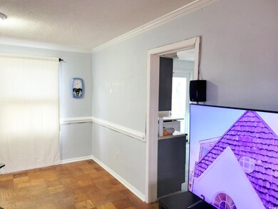 Corridor with crown molding, a textured ceiling, a