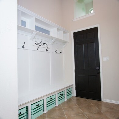 Spacious entry with built in bench, hooks and shelves.
