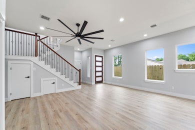 Spacious living area with recessed lighting and tile floors