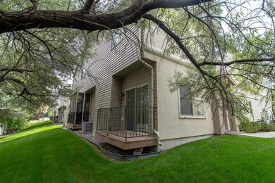 Back of house with a yard, stucco siding, and a deck