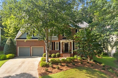 View of front of property featuring brick siding, driveway, a front yard, and an attached garage
