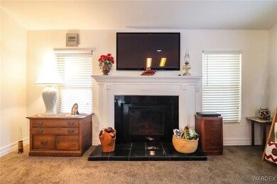 Carpeted living room with a tiled fireplace