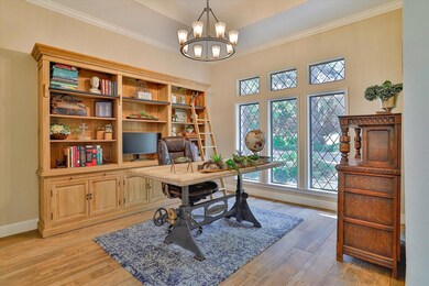 Office with a chandelier, crown molding, and light