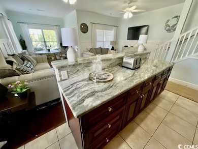 Kitchen with light stone counters, a kitchen islan