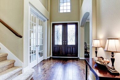 Double front doors highlight the light filled interior . To the left is the downstairs study or sitting room. To the right is the dining room.