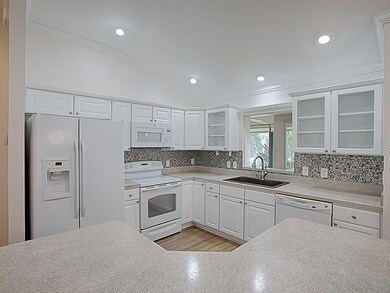LOVELY OPEN KITCHEN WITH WHITE CABINETRY WITH TRIM