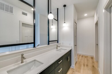Bathroom featuring double vanity, recessed lighting, and wood finished floors