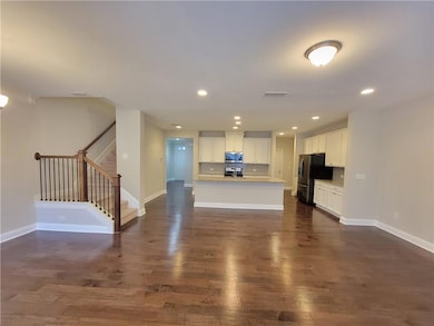 Unfurnished living room with stairs, dark wood-sty