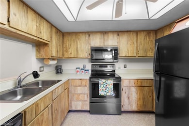 Kitchen featuring electric range, a sink, light co