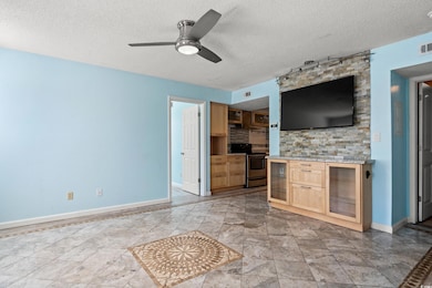 Unfurnished living room with a textured ceiling and a ceiling fan