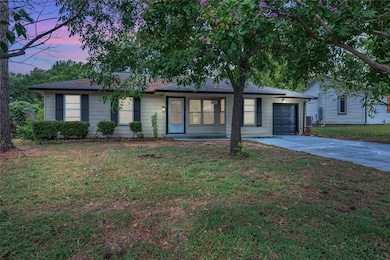 Ranch-style house with an attached garage, driveway, and a front yard