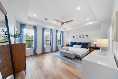 The spacious primary suite is bathed in natural li