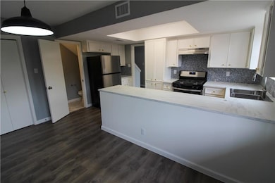 Kitchen with visible vents, a sink, stainless ste