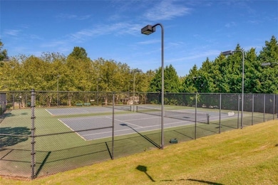 View of tennis court featuring a yard and fence