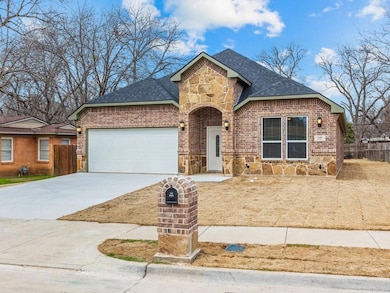 View of front of house featuring a garage, brick s