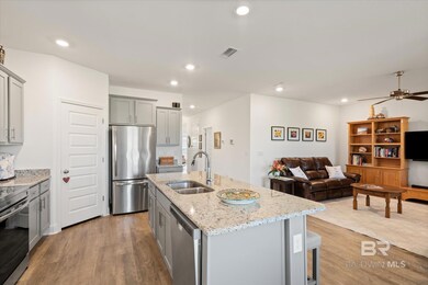 Kitchen featuring recessed lighting, gray cabinets, appliances with stainless steel finishes, wood finished floors, and a sink