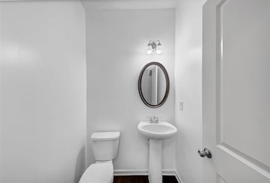 Half bath featuring toilet and wood finished floors