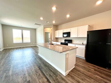 Kitchen featuring black appliances, white cabinet