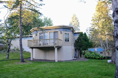 Back of house with a lawn and a deck. Main suite h