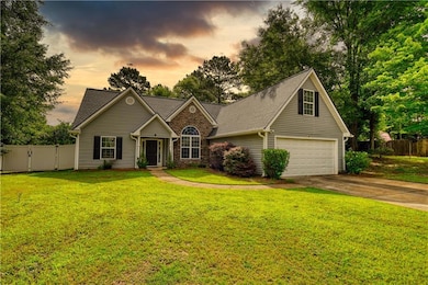 Traditional-style house featuring a garage, driveway, and roof with shingles