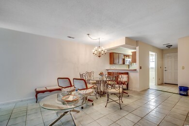 Dining space featuring a chandelier, light tile patterned floors, baseboards, and a textured ceiling