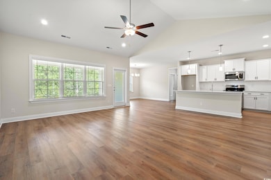 Unfurnished living room with a ceiling fan, wood finished floors, recessed lighting, and high vaulted ceiling
