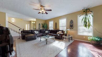 The expansive Living Room features Engineered Hardwoods, high ceilings and a Gas Fireplace with stone façade and gorgeous wooden mantle.