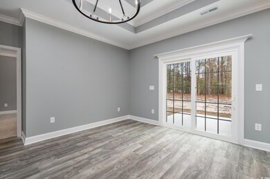 Empty room with hardwood / wood-style floors, a notable chandelier, and crown molding