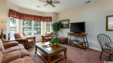 Carpeted living room with ceiling fan