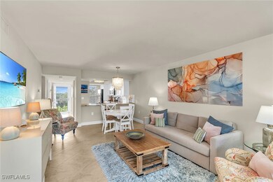 Tiled living room with a chandelier and baseboards