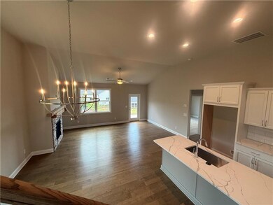 Unfurnished living room featuring a chandelier, lofted ceiling, dark wood-style flooring, ceiling fan, and recessed lighting