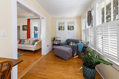 Sunroom with large cased opening to living room.