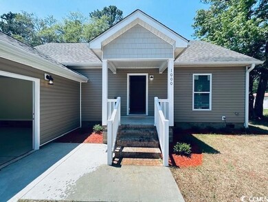Property entrance with a shingled roof and a yard