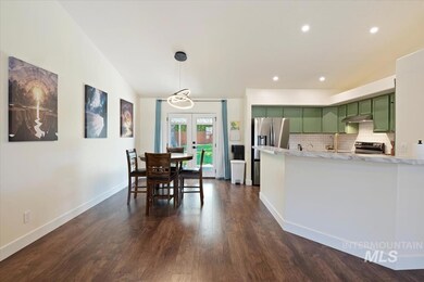 Kitchen with green cabinets, stainless steel fridge with ice dispenser, light countertops, a peninsula, and backsplash