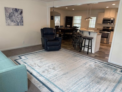 Living area featuring baseboards, arched walkways,