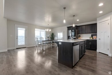 Kitchen with a healthy amount of sunlight, appliances with stainless steel finishes, a chandelier, and light countertops