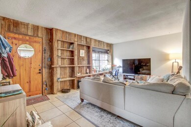 Living room with wood walls, a textured ceiling, 