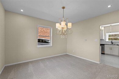 Spare room with recessed lighting, light colored carpet, and a chandelier