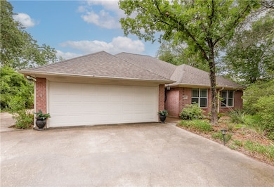 Ranch-style house with brick siding, concrete driv