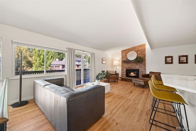 Upper-level living room with fireplace, hardwood floors, and large windows for natural light.