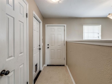 Doorway to outside with baseboards and a textured wall