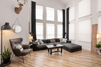 Living room with crown molding, high vaulted ceili