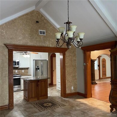 Kitchen featuring a center island, appliances with stainless steel finishes, light hardwood / wood-style floors, beamed ceiling, and white cabinetry
