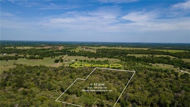 Wooded acreage with small clearings and paved coun